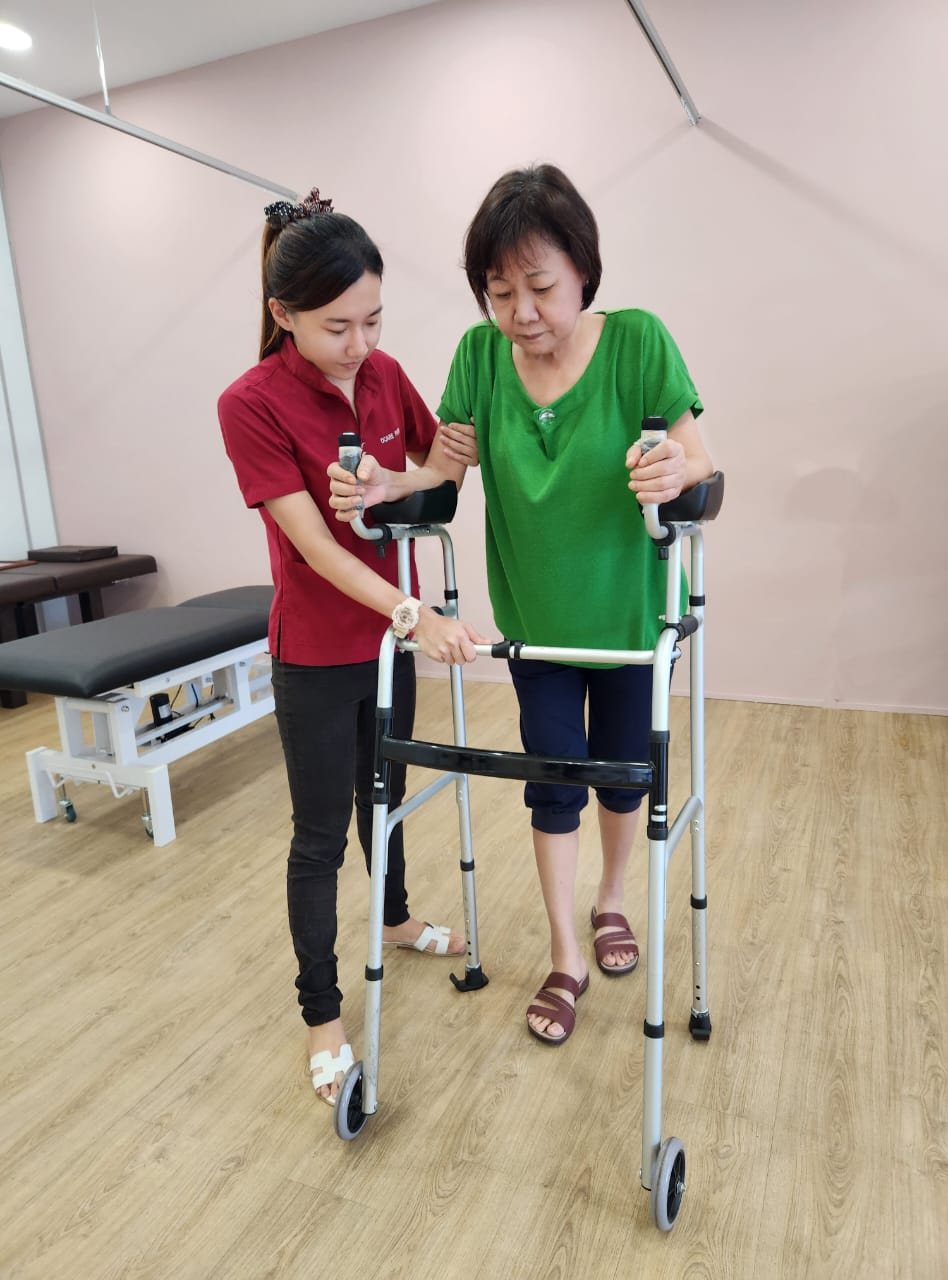 A therapist guiding a patient through walking practice at the Ocare centre
