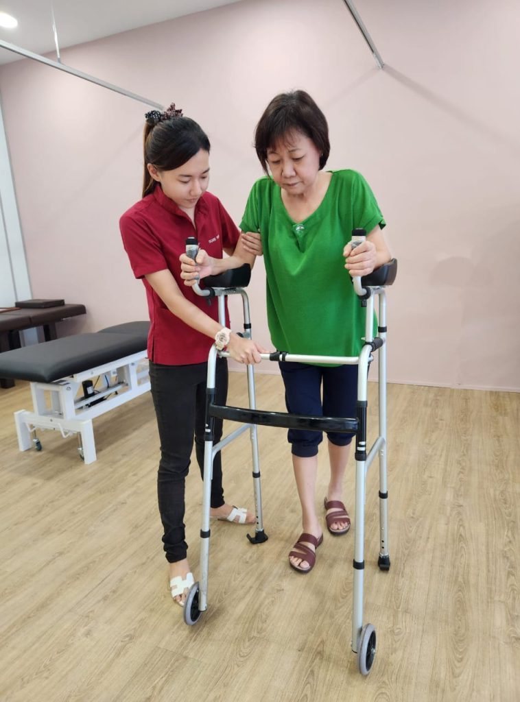 A therapist guiding a patient walking with a frame at the Ocare centre