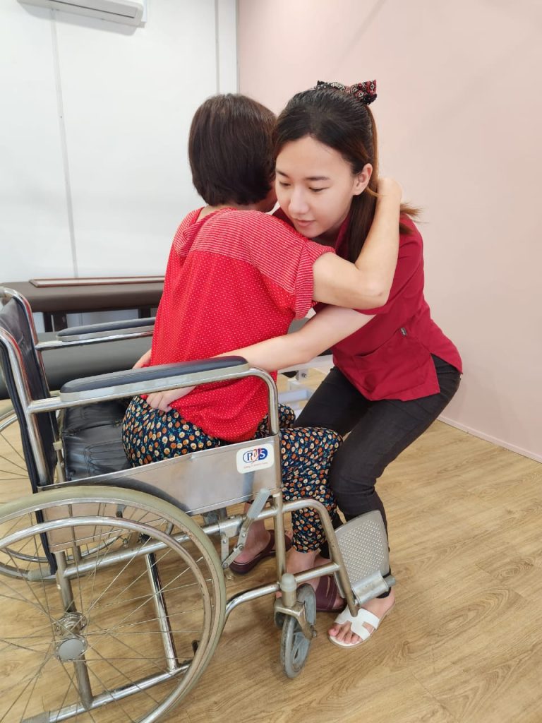 "Physiotherapist guiding an elderly patient in using a walking frame for gait training and mobility improvement at Ocare Physio Melaka."