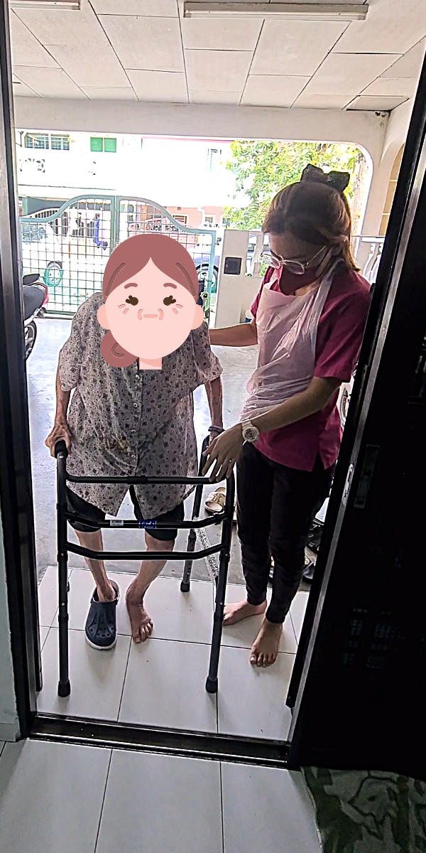 "Ocare Physio therapist assisting an elderly patient with walking frame exercises during a home visit physiotherapy session in Melaka."